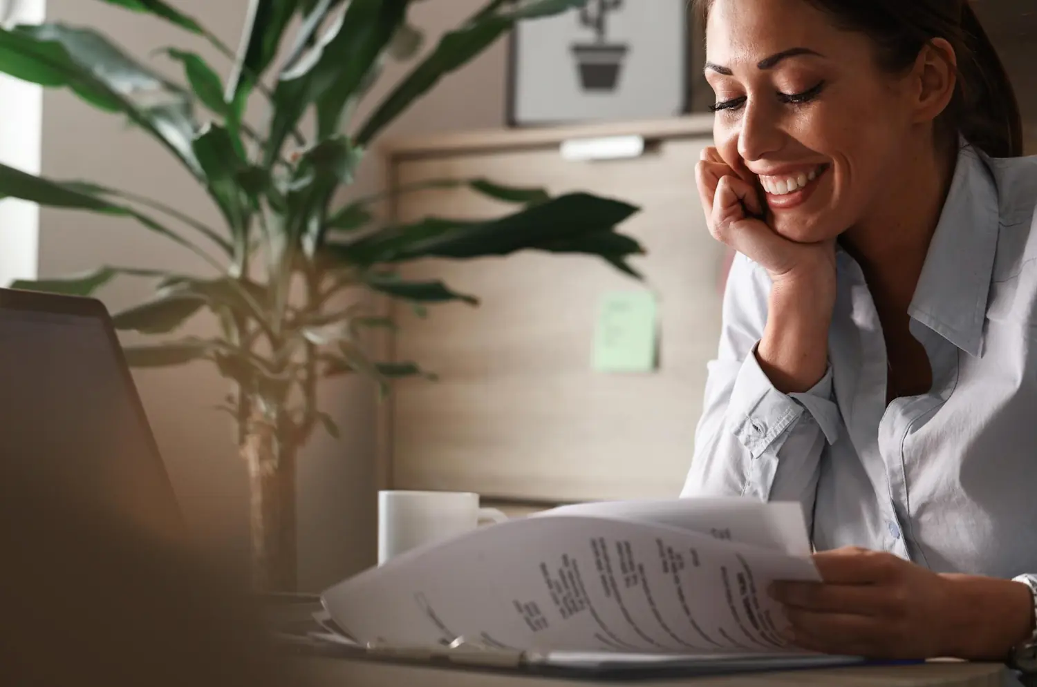 Smiling woman reviewing insurance paperwork for massage and osteopathy coverage