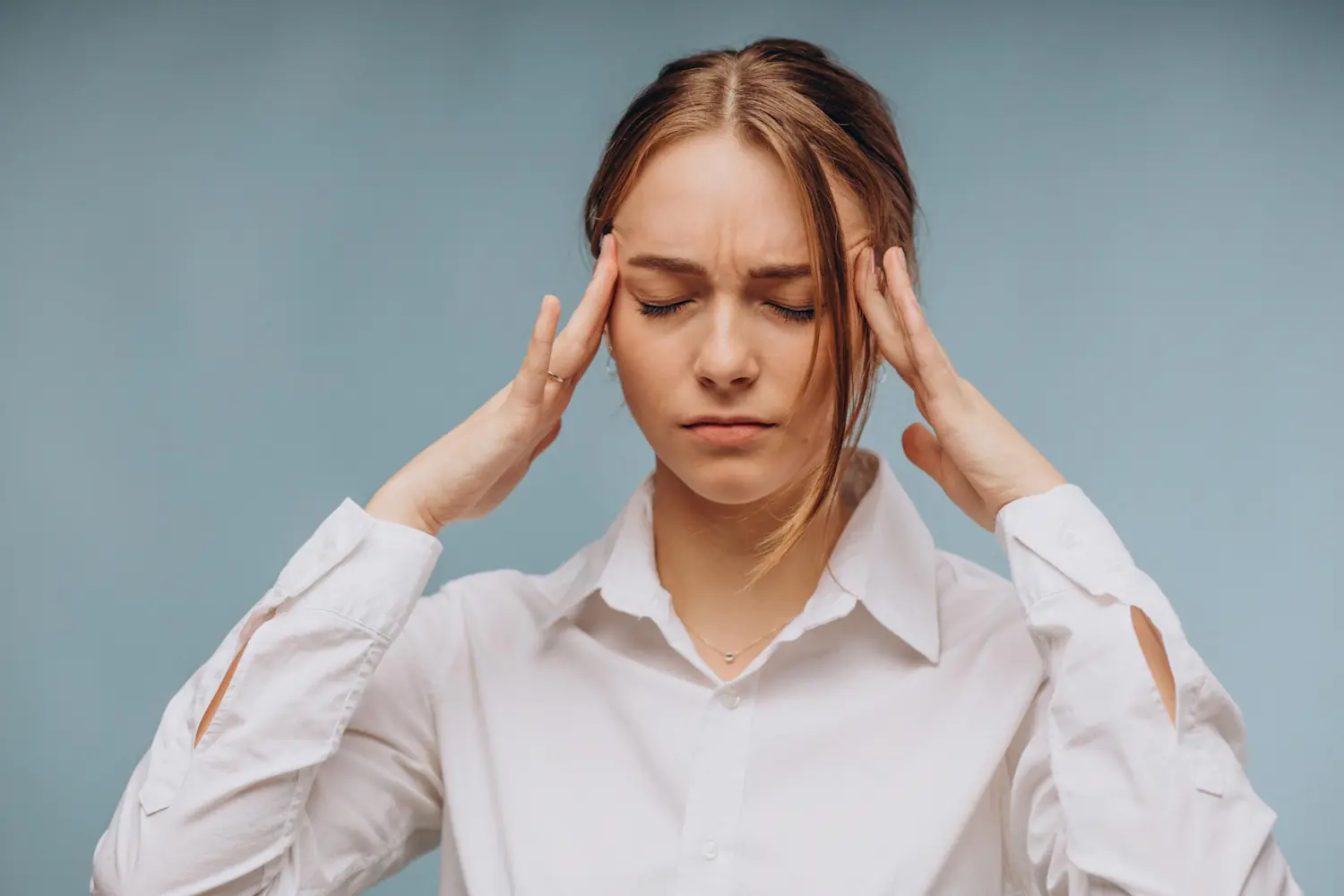 Woman pressing her temples during a headache