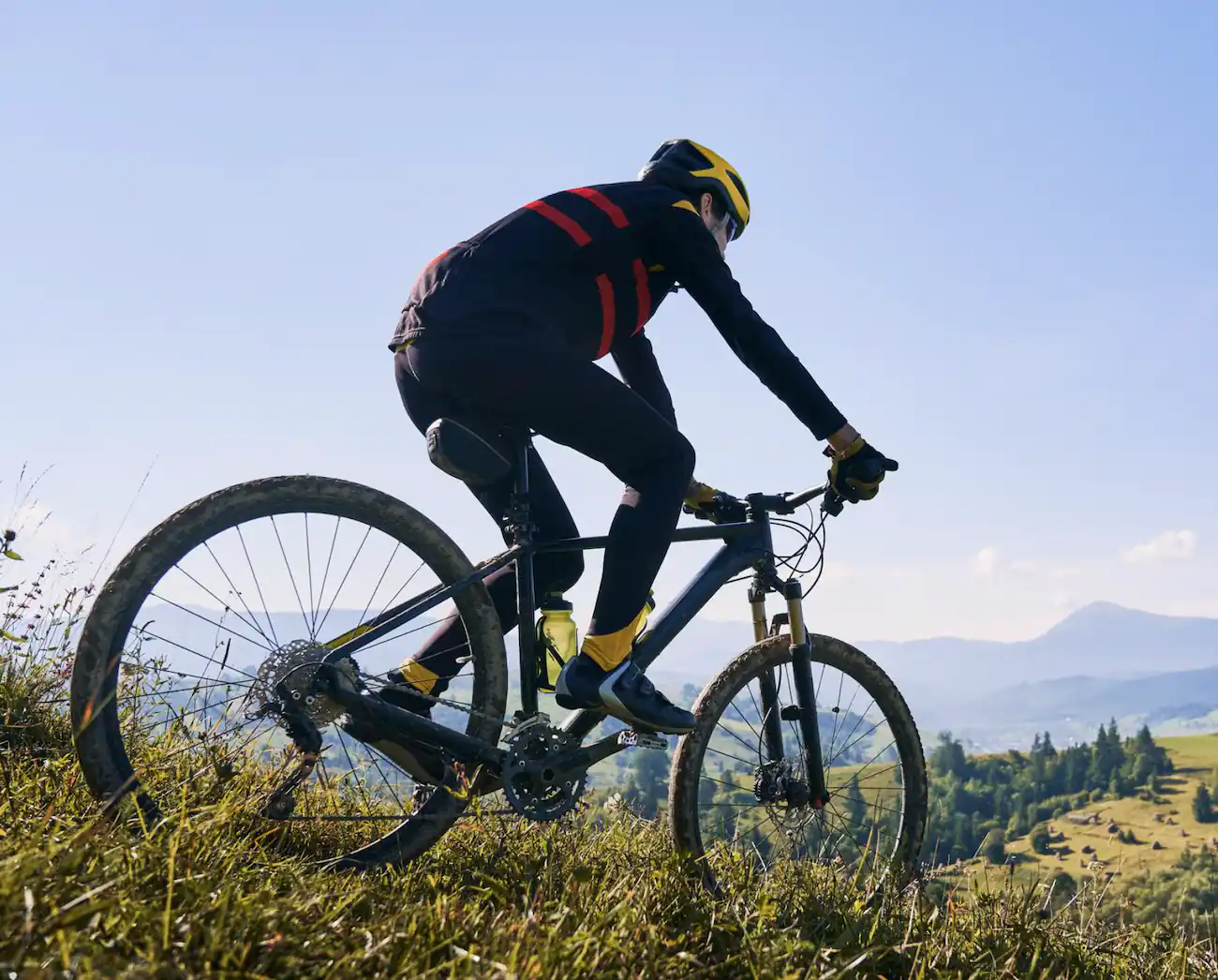 Mountain biker riding across a grassy hillside
