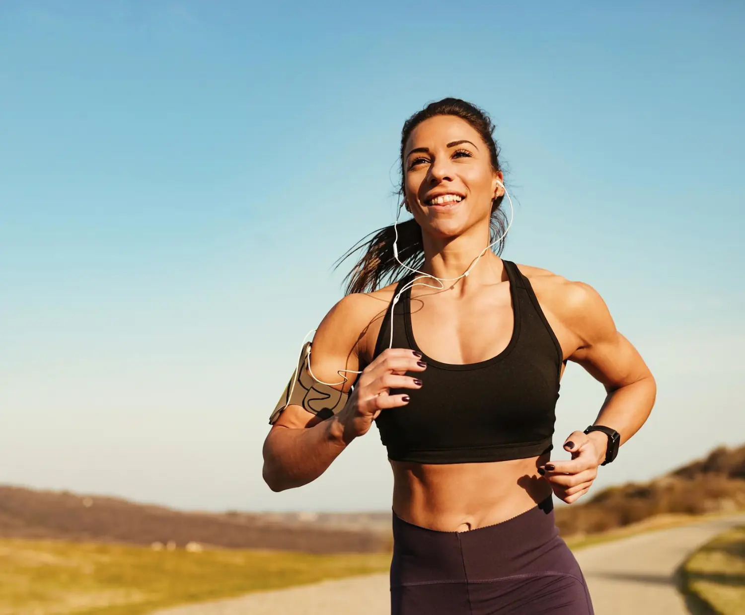 Smiling woman running outdoors on a sunny day
